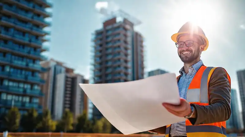 Ingeniero civil sonriente en obra moderna