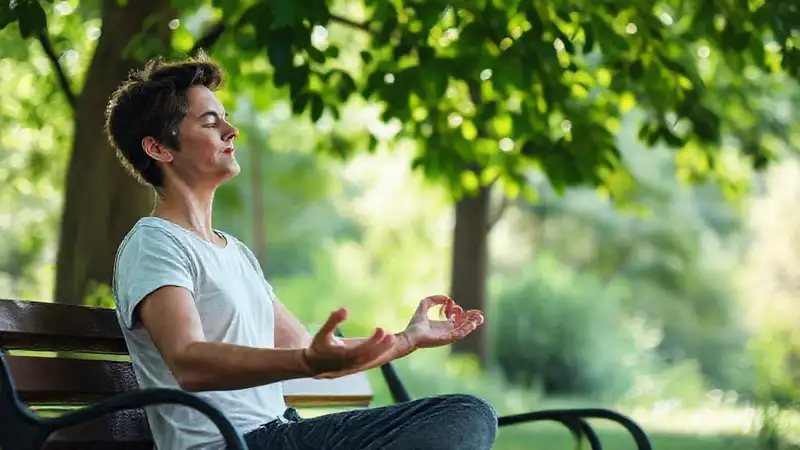 Persona meditando en parque tranquilo y relajado