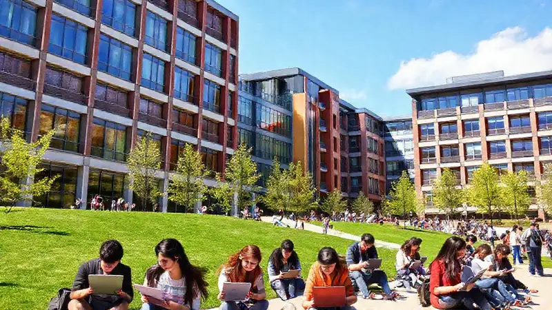Campus universitario moderno con estudiantes estudiando al aire
