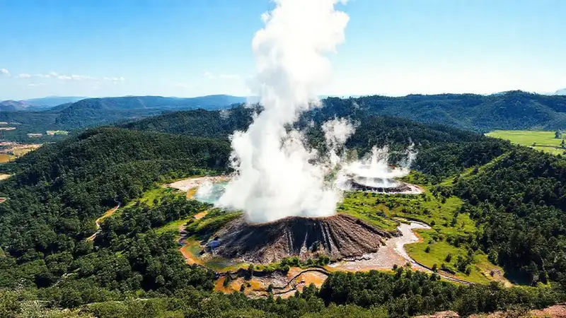 Planta geotérmica en paisaje verde y vapor